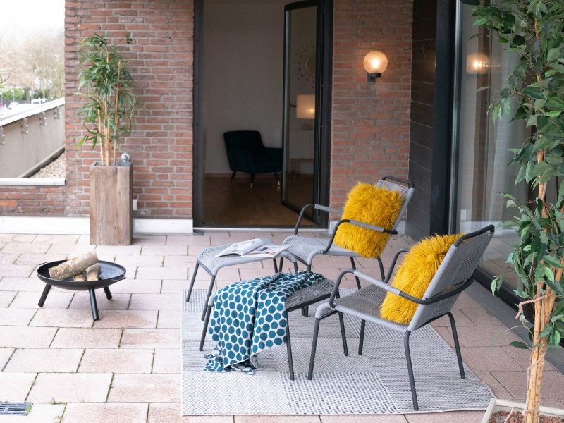 chaises avec coussin jaune sur une terrasse